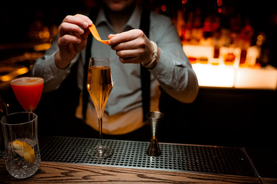 Bartender serving delicious champagne cocktail in night club