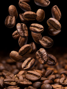 Fototapeta Falling coffee beans. Dark background with copy space