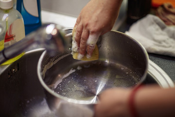 Hand cleaning. housewife woman washing dishes in kitchen.