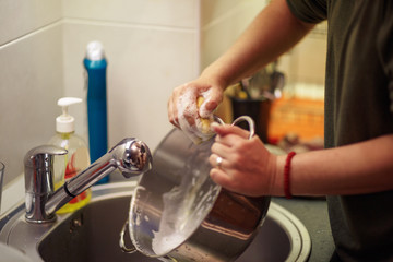 close up hands of woman washing dishes in the kitchen.