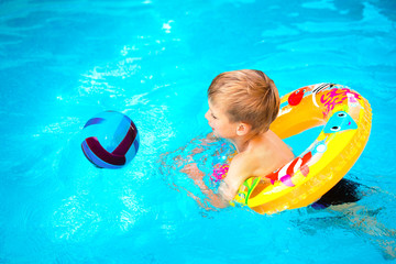 Boy floating on an inflatable circle in the pool