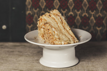 cake - Napoleon (puff cake with white cream) on a wooden table