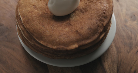 adding sour cream on top of pancakes or blini