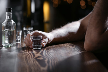 Man with glass of drink in bar, closeup. Alcoholism problem