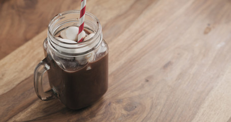 cocoa drink in glass jar with handle on wood table