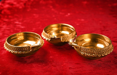 Diwali diyas or clay lamps on red fabric