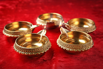 Diwali diyas or clay lamps on red fabric