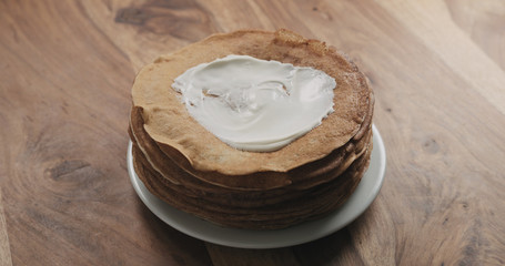 Fototapeta na wymiar sour cream on top of pancakes or blini