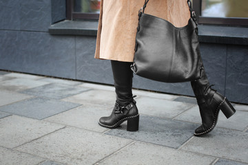 Stylish woman in black shoes walking down the street