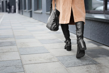 Stylish woman in black shoes walking down the street