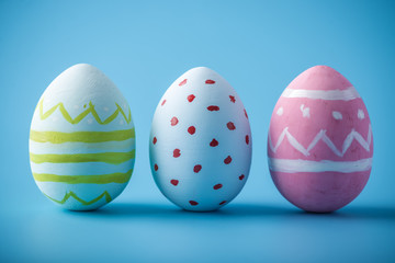 Colorful Easter eggs hand painted on a blue background. Holiday spring card