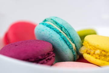 Разноцветные макаруны в белой тарелке
