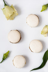 Белые макаруны с живыми цветами на белом фоне