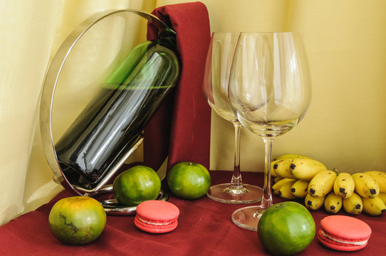 a bottle of wine glasses and fruit