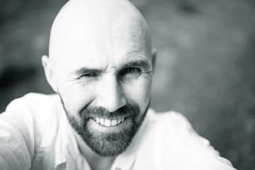 cheerful man with  smile,  bearded guy looks at the camera and laughs, a bright spring smile of a man