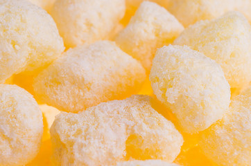 Sweet yellow corn sticks with powdered sugar background, closeup.