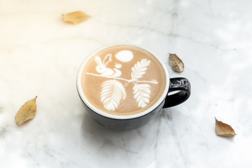 Hot world Latte art coffee Black cup on table and nature leaf background texture wallpaper.