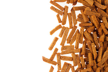 Brown roasted dry bread sticks croutons as decorative border with copy space, isolated. Fast food background, top view.