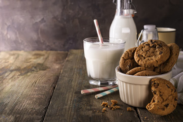Double chocolate cookies with chips on a bowl and milk in glass