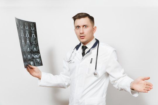 Shocked handsome young doctor man holds x-ray radiographic image ct scan mri isolated on white background. Male doctor in medical uniform, stethoscope. Healthcare personnel, health, medicine concept.