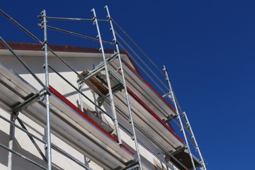 Renovation of a residential home with scaffolding against blue sky