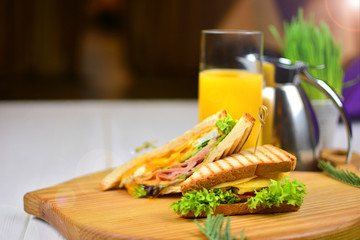 Background of a tasty morning breakfast with sandvich and orange juice.