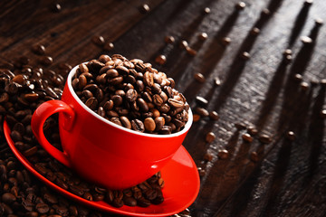 Composition with red cup of coffee and beans