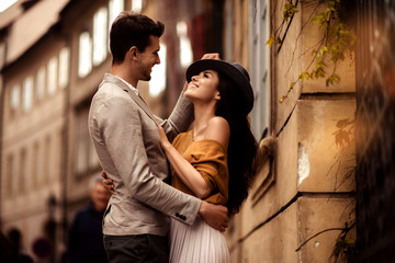 Passionate gorgeous young couple embrace each other while walk across ancient city. Cheerful...