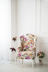 Chair with flowers near the window white classic background