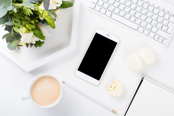 Lady bloggers work desk with fresh bouquet of flowers and macaro
