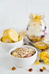 Breakfast in a jar: cornflakes, banana, fresh berries, granola, yogurt on a light background. The concept of healthy eating, high-carbon Breakfast.