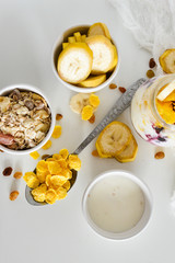 Breakfast in a jar: cornflakes, banana, fresh berries, granola, yogurt on a light background. The concept of healthy eating, high-carbon Breakfast.