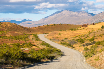 Beautiful scene of the road among yellow grassland beside lake tekapo before sunset.
