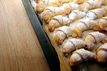 Freshly baked croissants on wooden background with copy space for a text or object