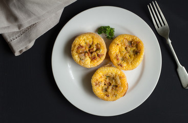 Quiche Lorraine backround, top view of three mini tartlets closeup on black table