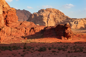Fototapeta na wymiar Red mountains of the canyon of Wadi Rum desert in Jordan. Wadi Rum also known as The Valley of the Moon is a valley cut into the sandstone and granite rock in southern Jordan to the east of Aqaba.