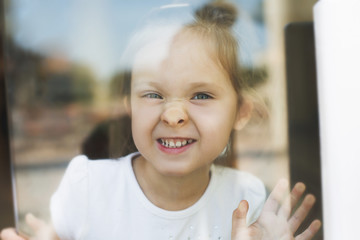 Little girl show emotions in window