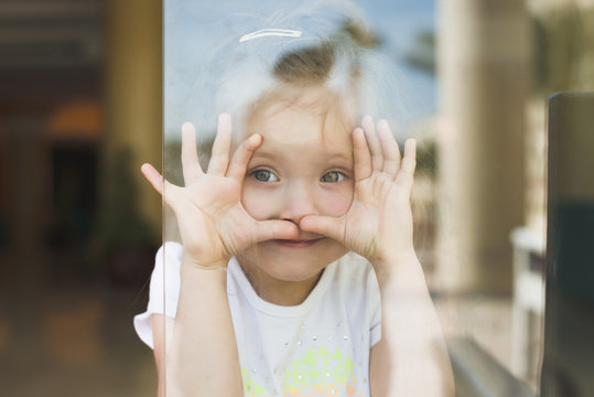Little girl show emotions in window