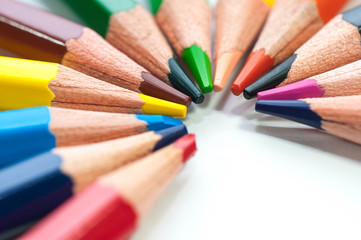 Fototapeta premium Group of color pencils forming a half circle close up macro shot isolated on white background.