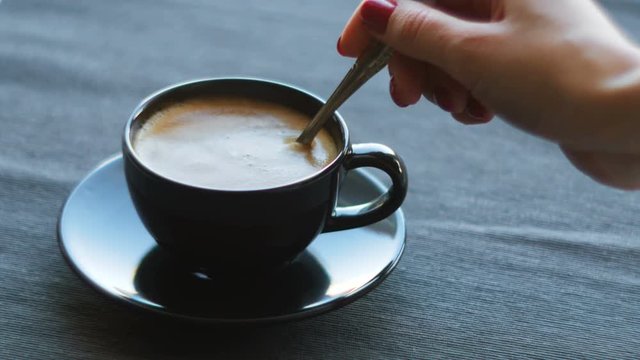 Cinemagraph of person mixing sugar in coffee cup