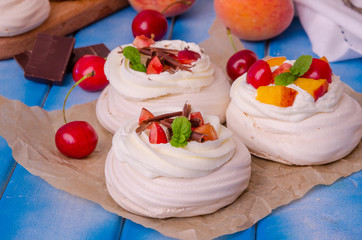 Meringue mini cake Pavlova with peaches and cherries
