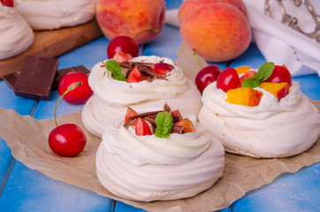 Meringue mini cake Pavlova with peaches and cherries