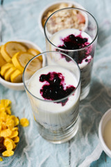 Healthy Breakfast: homemade granola, banana, fresh berries, yogurt in glass cups on light textile background. The concept of healthy eating, high-carbon Breakfast.