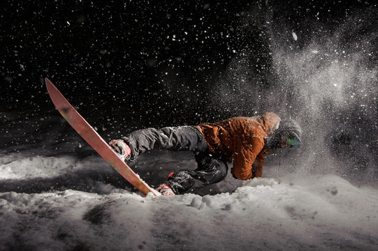 Man snowboarding at night under the snow