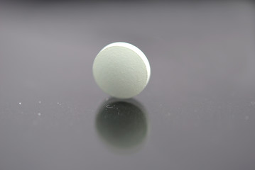 Alone round tablet with reflection closeup isolated