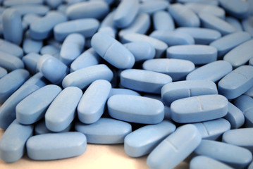 Big oval blue tablets closeup on white background