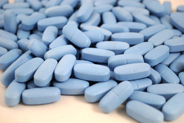 Big oval blue tablets closeup on white background