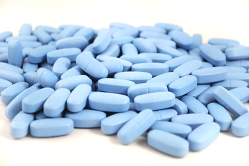 Big oval blue tablets closeup on white background