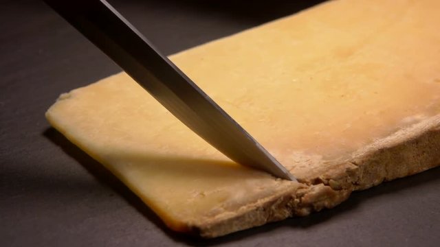 Hard French cheese Parmesan cut on a stone board