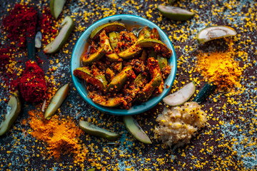 Close up of Aam ka achar or kari ka achar with all its ingredients and speiceis on a wooden surface in drak Gothic colors. - obrazy, fototapety, plakaty